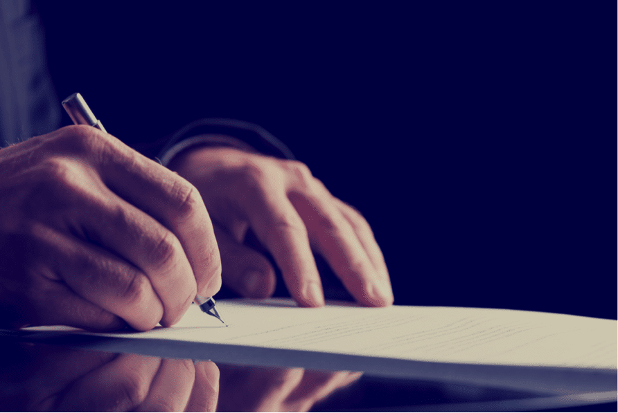 Close up of hands signing a will